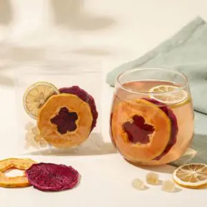 Papaya Dragonfruit Glow fruit tea with a transparent serving and a rosy fruit infusion showing papaya, dragon fruit and lemon