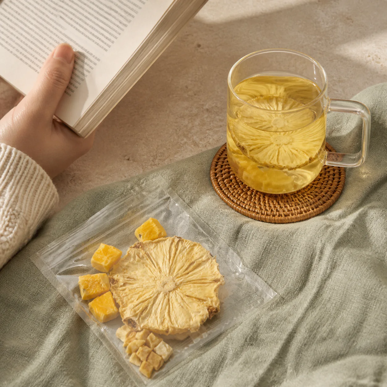 Pineapple mango fruit tea beside an open book in warm natural light