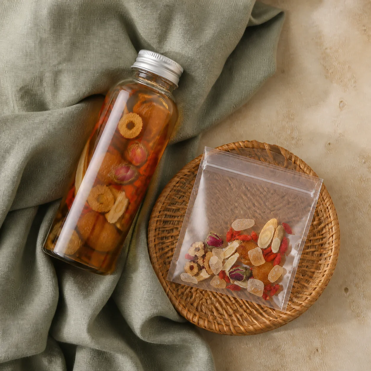 Rose goji herbal infusion bottle and individual pouches arranged on a rattan tray
